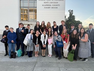 Mock trial students posing in front of huge building structure