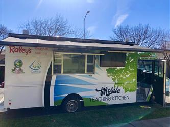 Side view of the Mobile Teaching Kitchen that shows the awning out over the service window and the TV.
